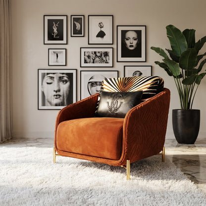 Modern living room featuring a burnt orange velvet armchair, gold legs, luxury decor, and a gallery wall of black-and-white art.